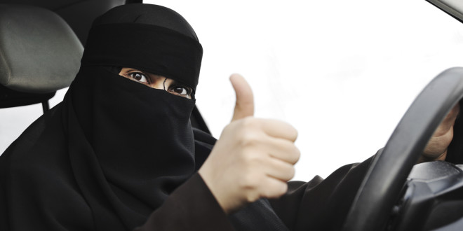 Excited Arabic Muslim woman with veil and scarf  driving car