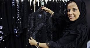 In this Saturday, April 13, 2013 photo, Saudi fashion designer Hania al-Braikan presents an abaya selling for about $1500 at a bridal exhibition in Dubai, United Arab Emirates.  Just a few years ago, Gulf Arab women usually only felt comfortable showing off their fashion sense at ladies-only parties or family gatherings. In public, at least in their home countries, the standard all-black abaya _ a simple floor-length covering and accompanying head scarf _ was the only culturally accepted option. But now a new generation of abaya designers are giving the traditional garment a twist with choices of fabric, designs and even some expensive bling to allow Gulf women a host of style options. (AP Photo/Kamran Jebreili)