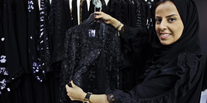 In this Saturday, April 13, 2013 photo, Saudi fashion designer Hania al-Braikan presents an abaya selling for about $1500 at a bridal exhibition in Dubai, United Arab Emirates.  Just a few years ago, Gulf Arab women usually only felt comfortable showing off their fashion sense at ladies-only parties or family gatherings. In public, at least in their home countries, the standard all-black abaya _ a simple floor-length covering and accompanying head scarf _ was the only culturally accepted option. But now a new generation of abaya designers are giving the traditional garment a twist with choices of fabric, designs and even some expensive bling to allow Gulf women a host of style options. (AP Photo/Kamran Jebreili)